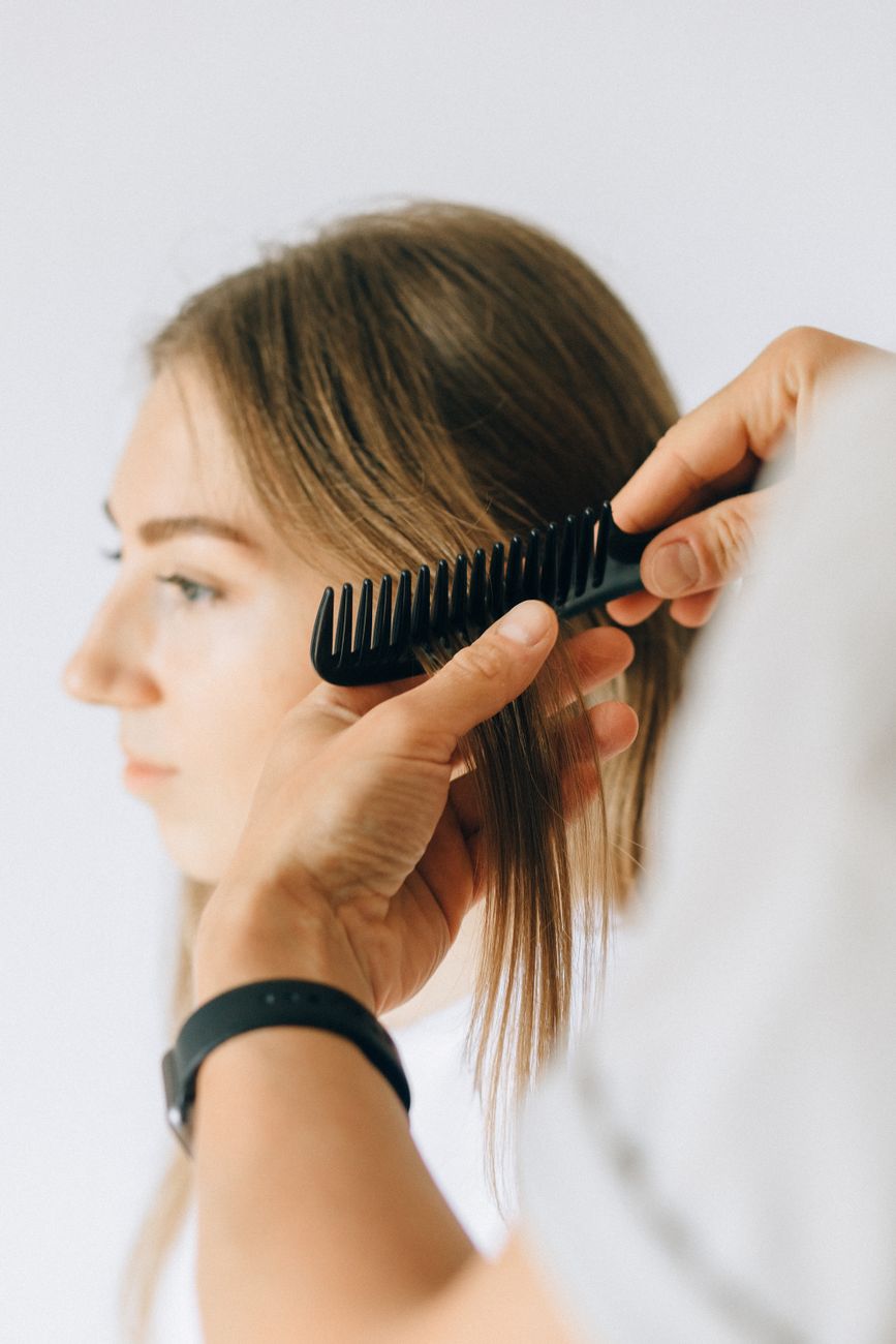 Glass Hair Finish: The Ultimate Guide to Mirror-Like Straight Styling 1 a woman having her haircut