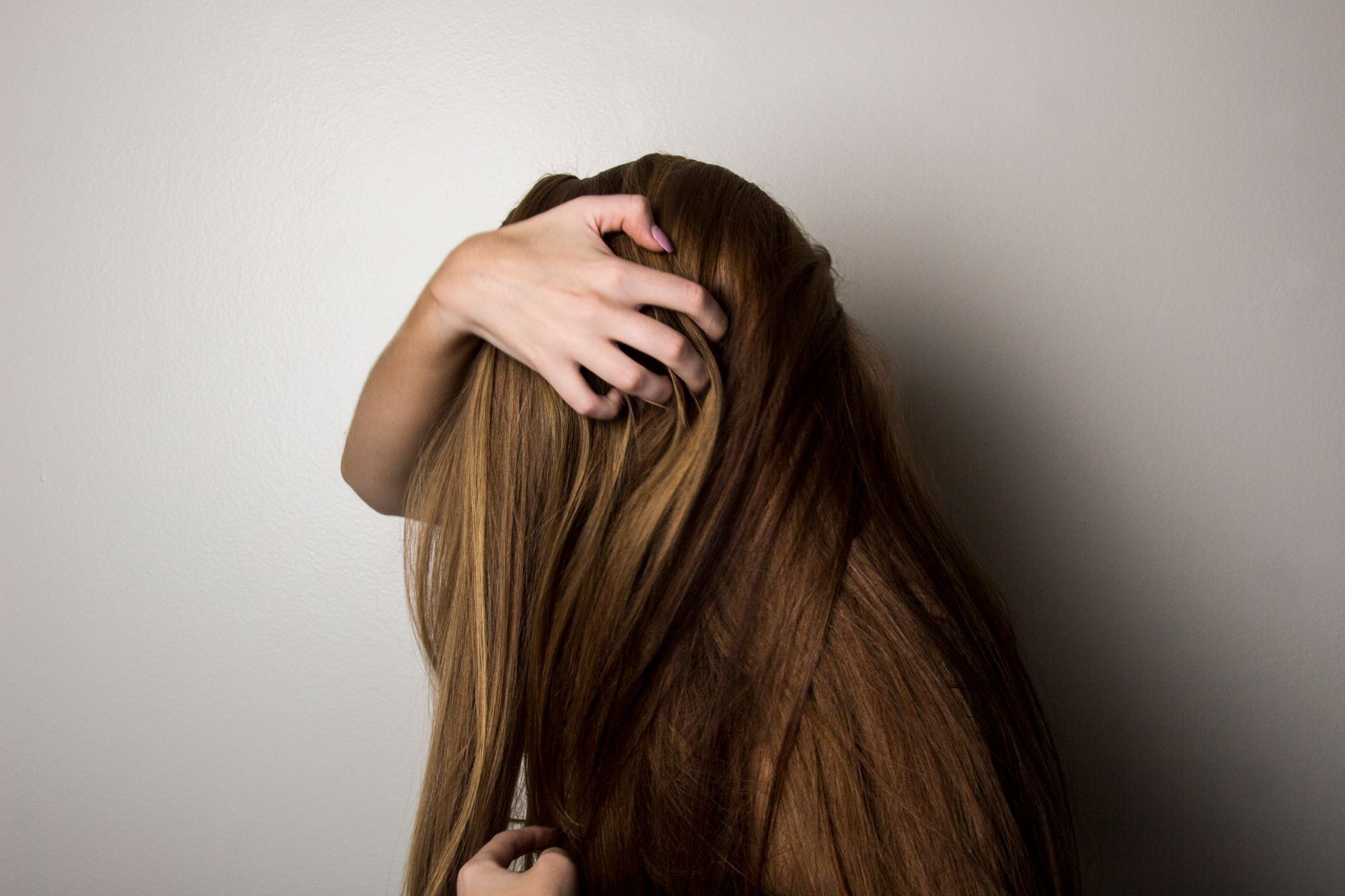 Preserving Scalp Health Under Hair Extensions and Wigs 1 photo of woman covering face with her hair