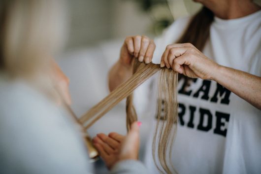 women hands holding blonde hair