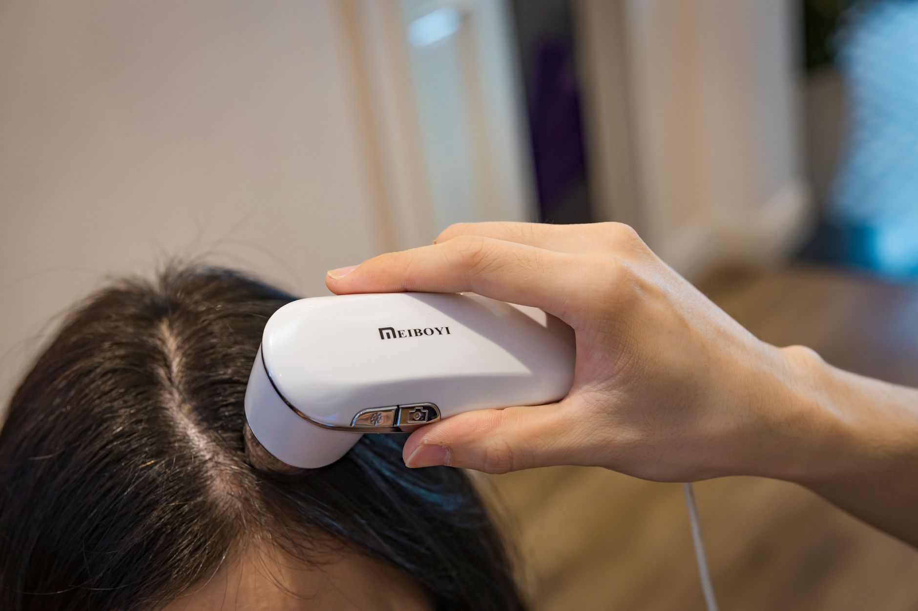 Custom Scalp Consultations at OP Hair Salon: Personalized Care for a Healthier Scalp 1 woman holding a device