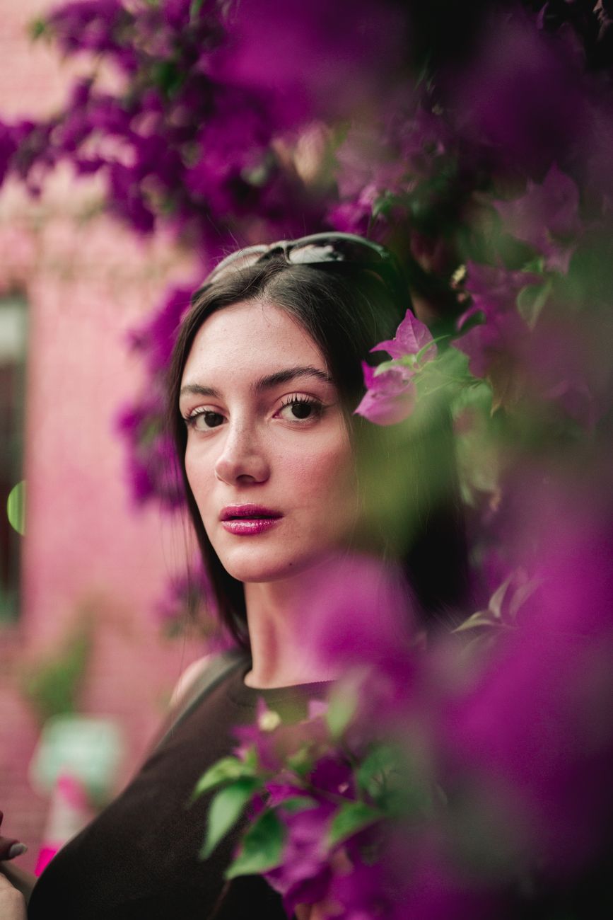 woman posing among blooming flowers