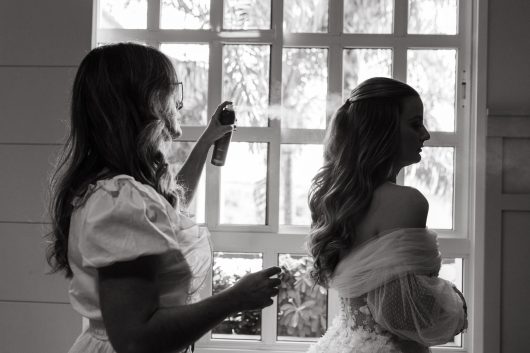 Mother of the Bride Styling Ideas: Sophisticated and Modern 1 woman using hairspray on the brides hair