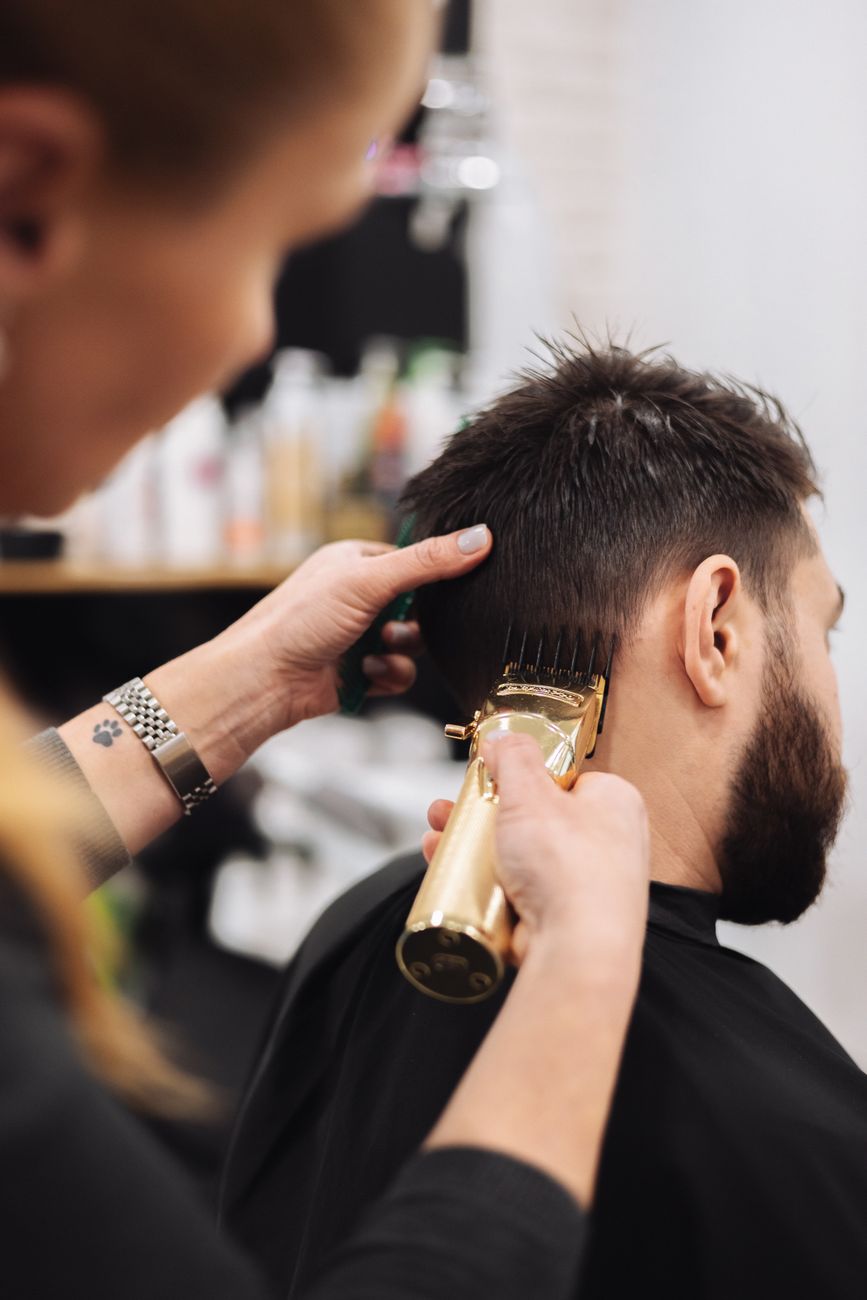 woman trimming man hair