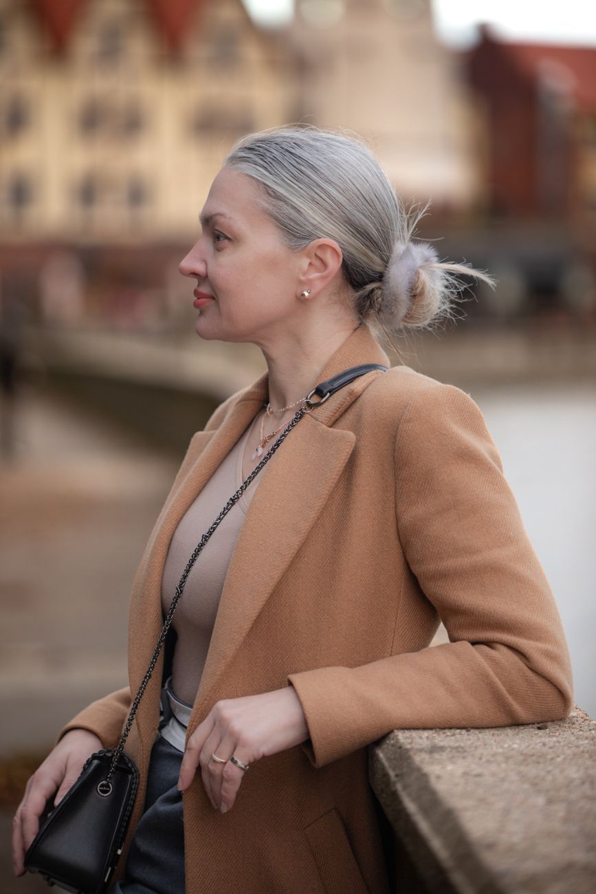 Warm vs. Cool Tones for Gray Coverage: What Flatters Mature Skin? 1 stylish woman in camel coat outdoors