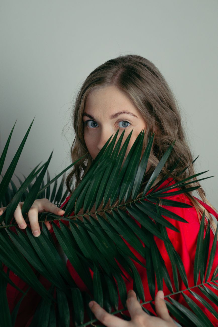 Peekaboo Vivid Color: Subtle Pop of Brightness Beneath 1 mysterious woman peeking through leaves