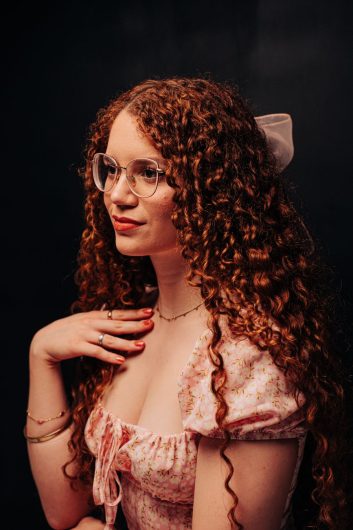 The Secret to Long-Lasting Curls for Formal Occasions 1 portrait of a woman with curly red hair and glasses