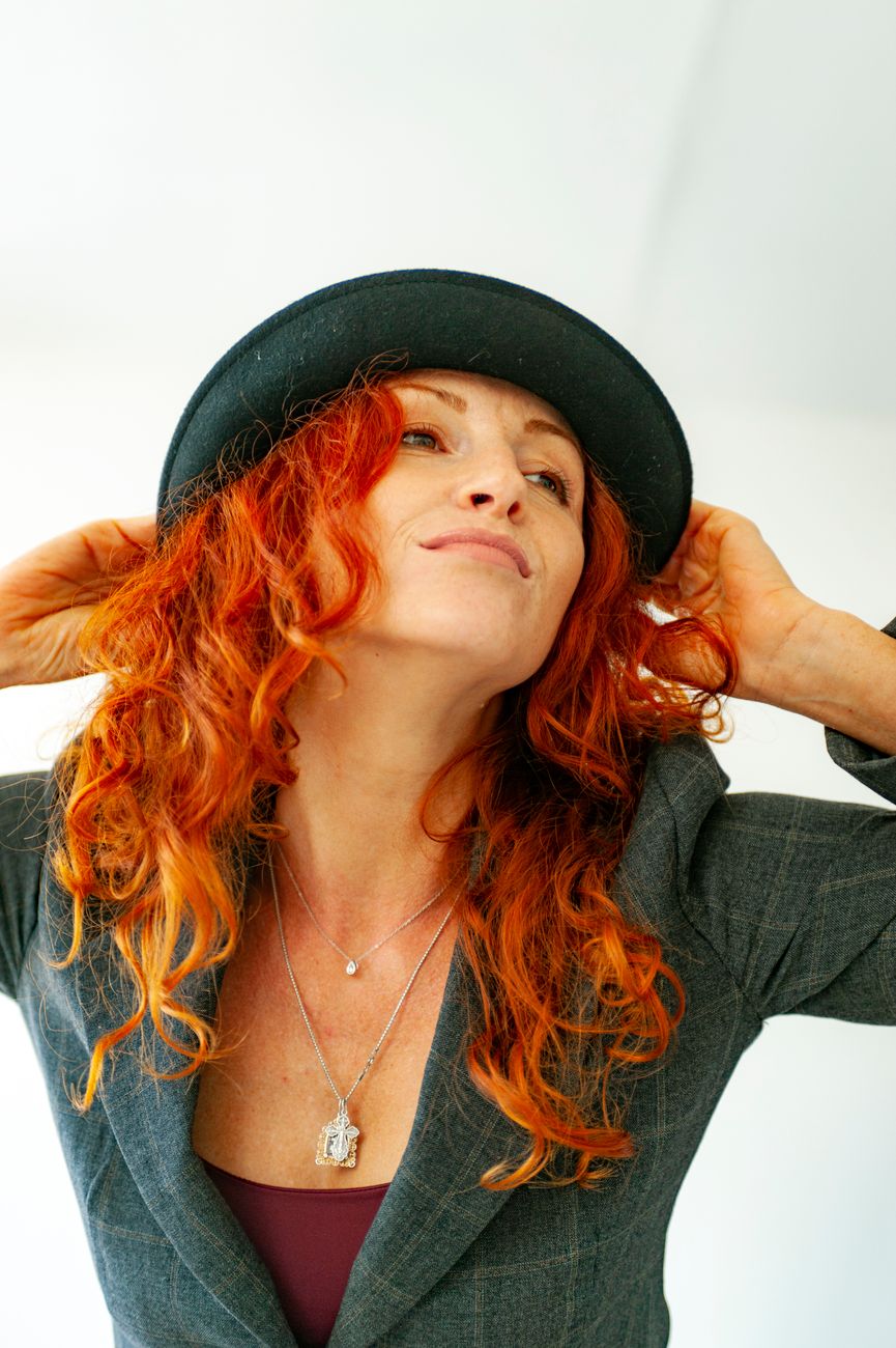 Transitioning to Natural Gray Hair Gracefully With Silver Highlights 1 confident woman with red hair in stylish hat