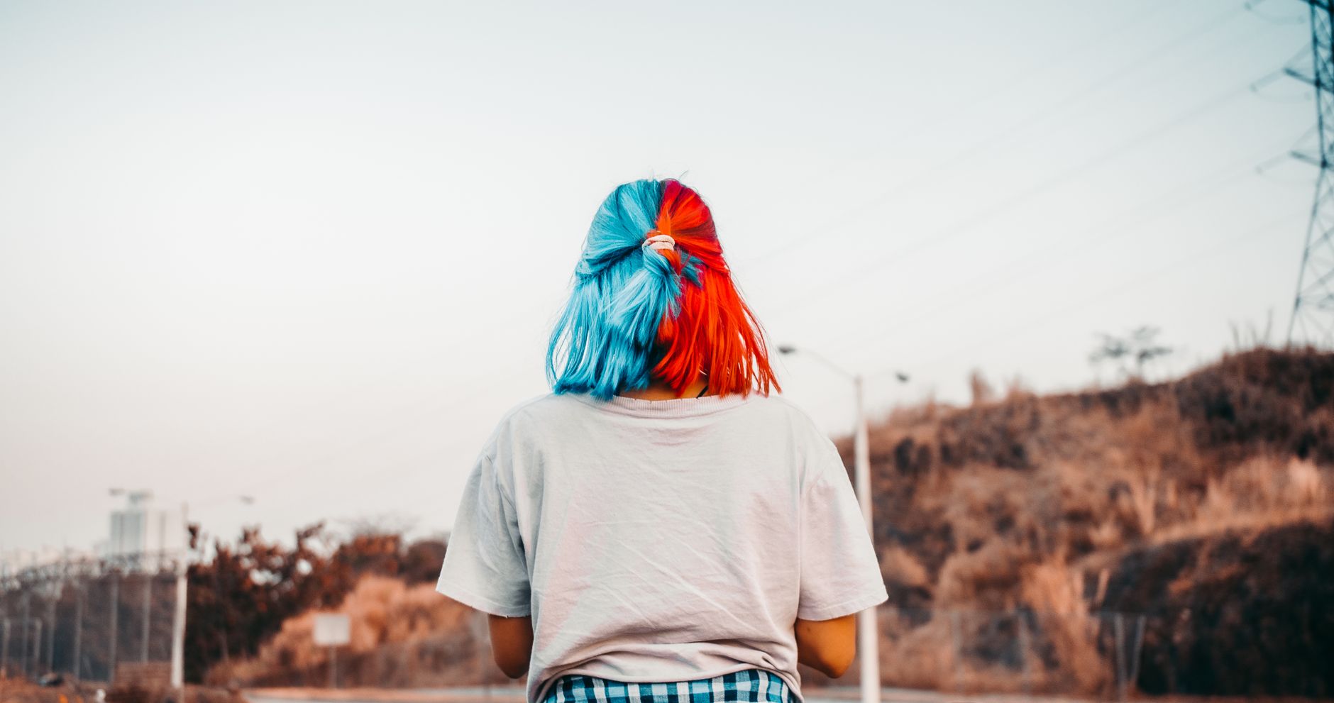 back view photo of woman in gray t shirt with blue and orange hair