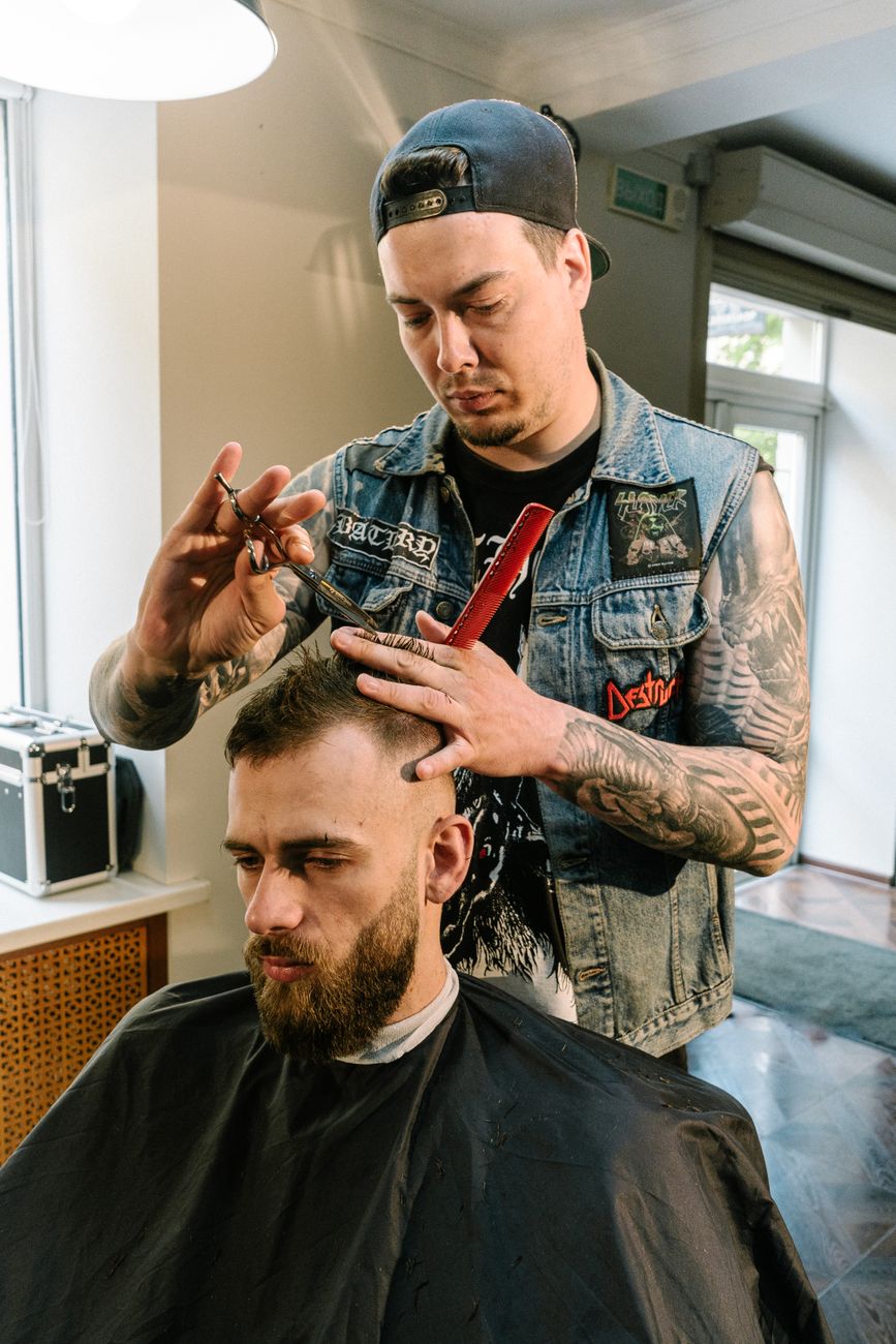 man cutting another man s hair