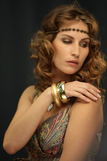Prom and Gala Hair Trends: Modern Updos and Sleek Pony Styles 1 woman wearing gold bangles
