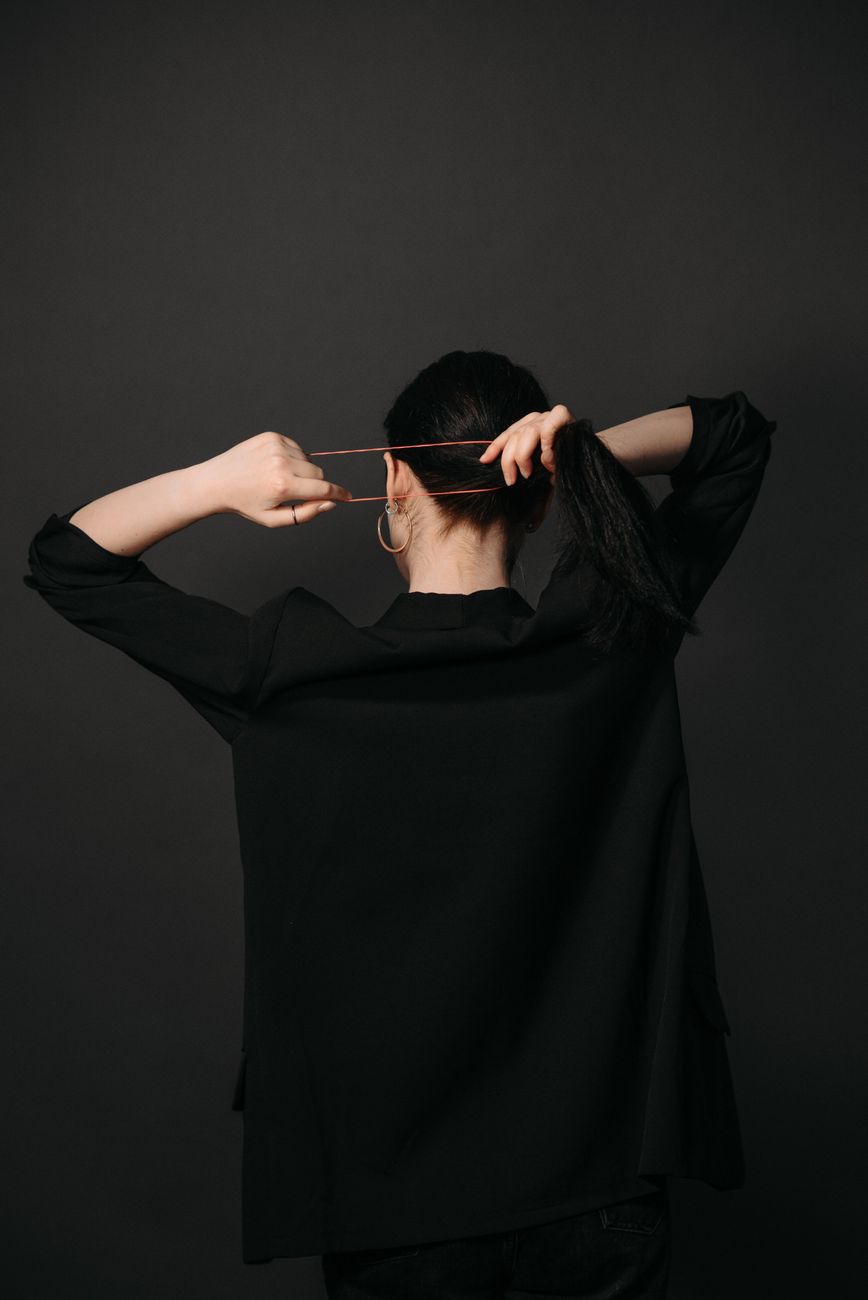 Chic Low Ponytails for Black-Tie Events 1 a woman tying her hair