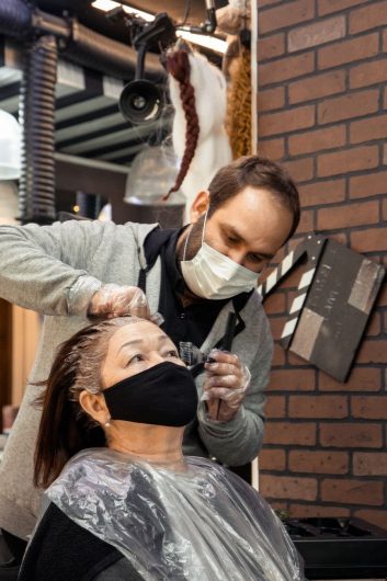 professional hairdresser dying hair for elderly woman