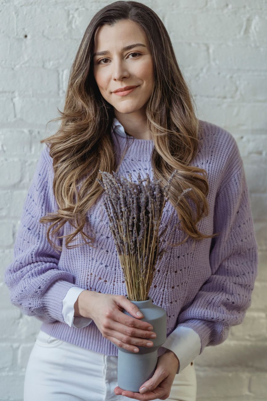 smiling woman with long hair standing bunch with blooming flowers