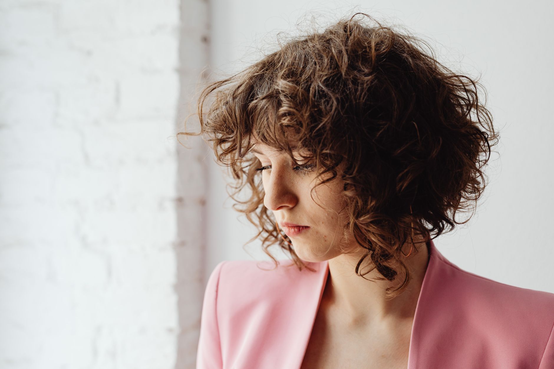 The Return of the Shag Haircut: Modern Texture for All Lengths 1 pretty woman in pink blazer looking down
