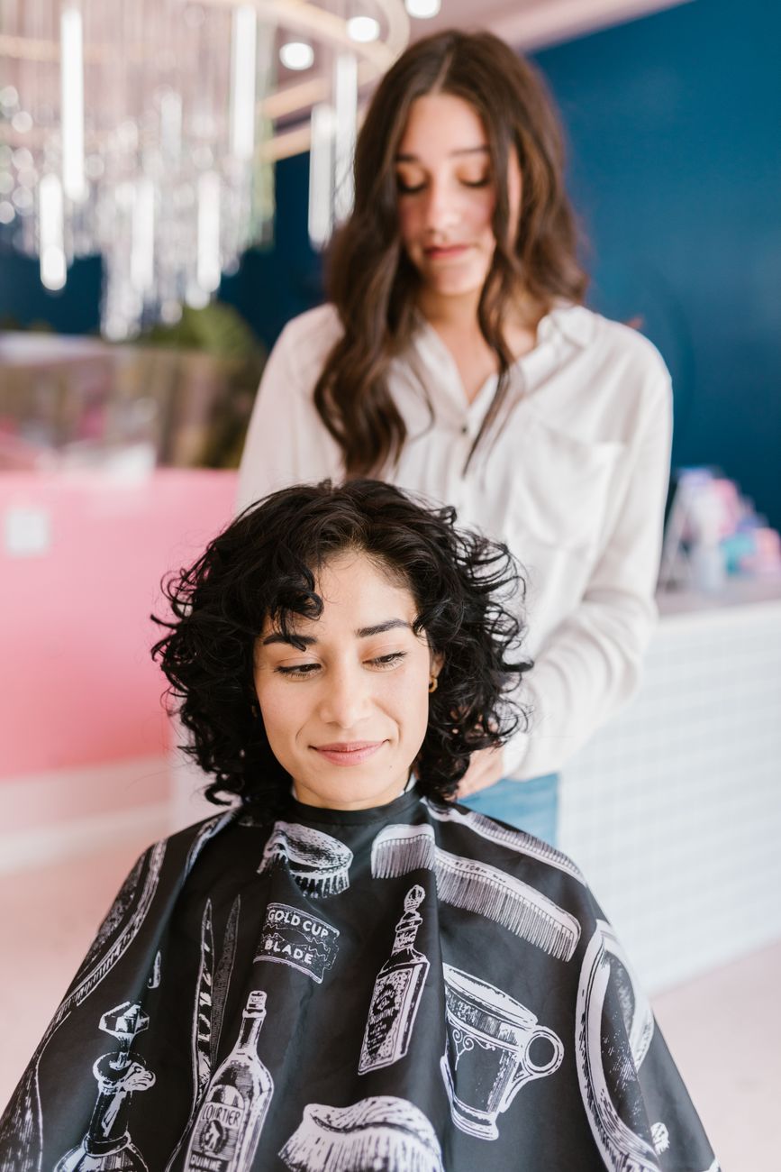 woman sitting with black salon cape
