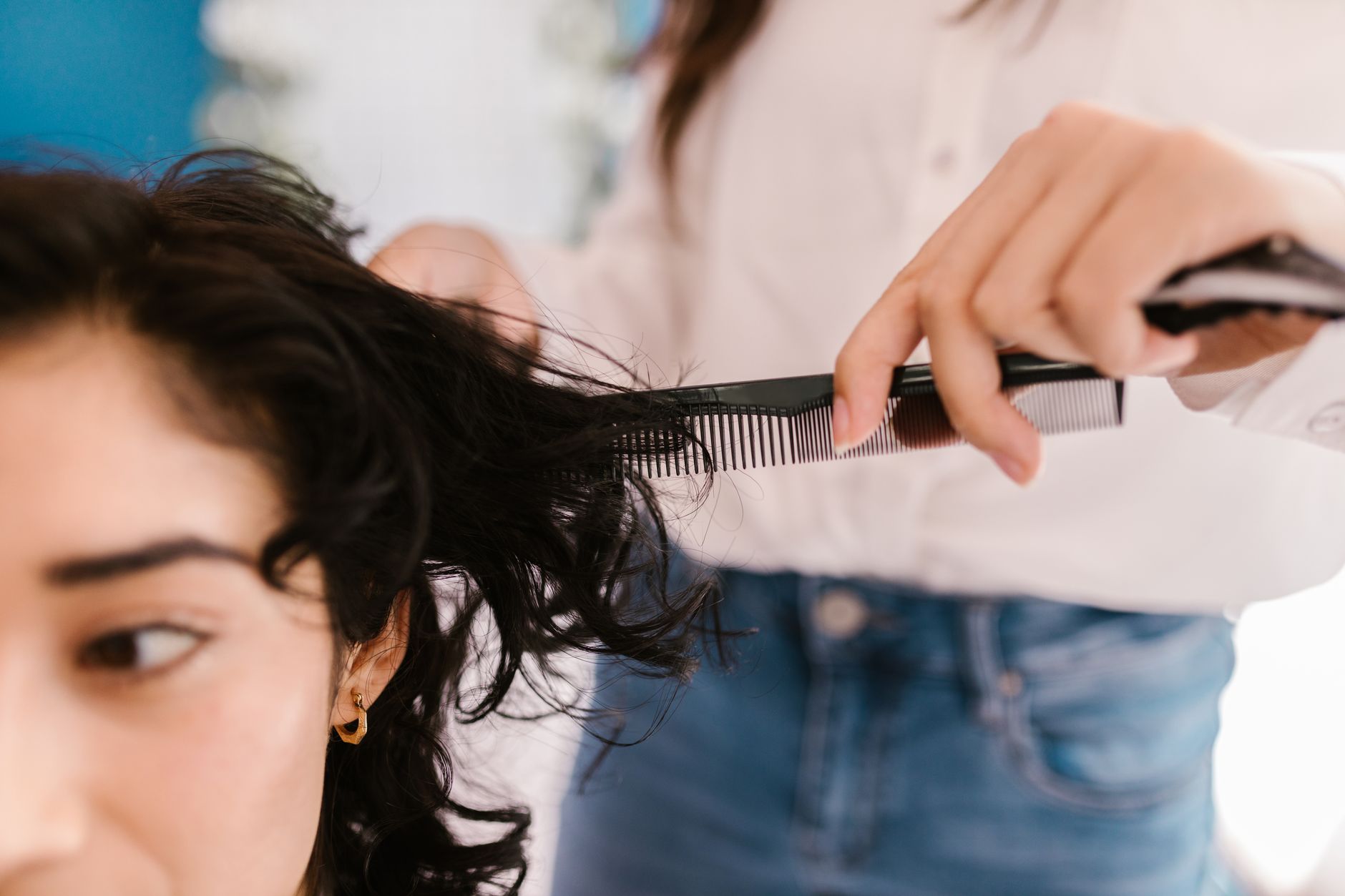 Sculpted Curly Haircuts: Custom Dry Cutting Techniques 1 a woman in blue denim jeans holding a hair comb